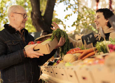 cheerful-woman-giving-box-full-fresh-fruits-veggies